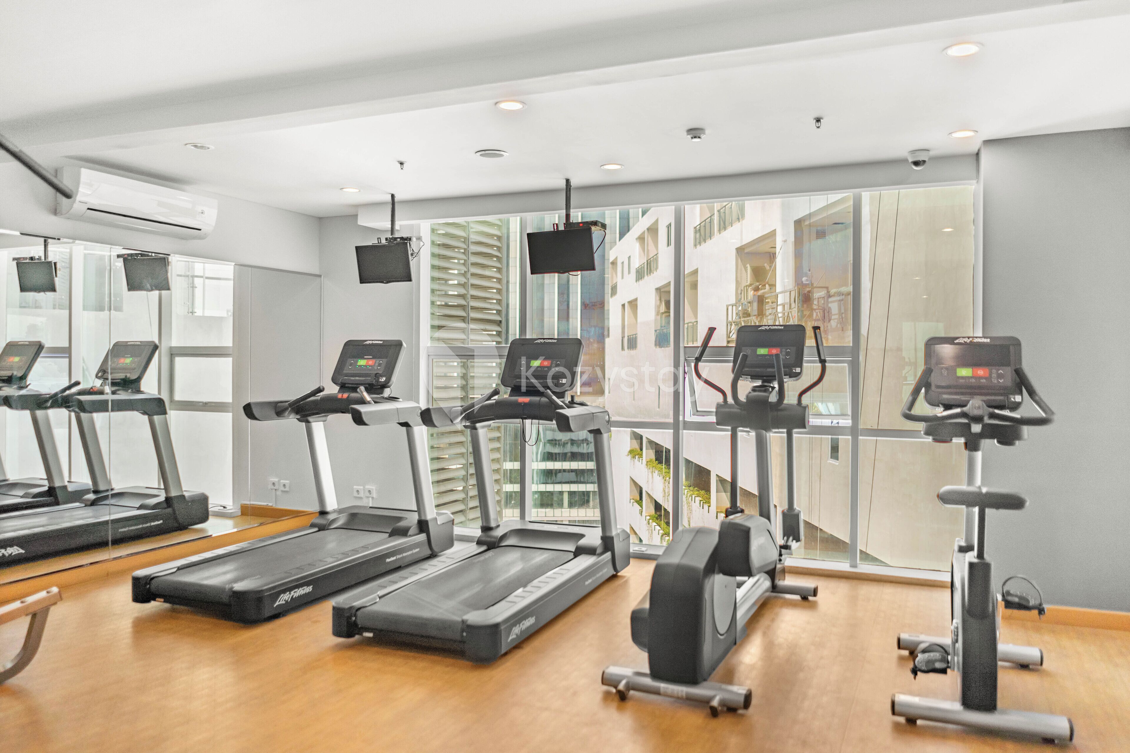 A gym with treadmills, elliptical machines, and a stationary bike.