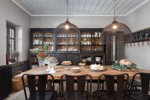 A dining area with a wooden table, black chairs, and a black cabinet with glass doors.