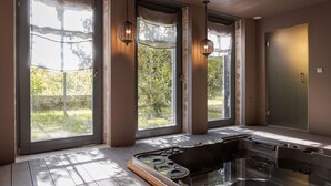 Een moderne badkamer met een douchecabine van glas, grote ramen en hanglampen.