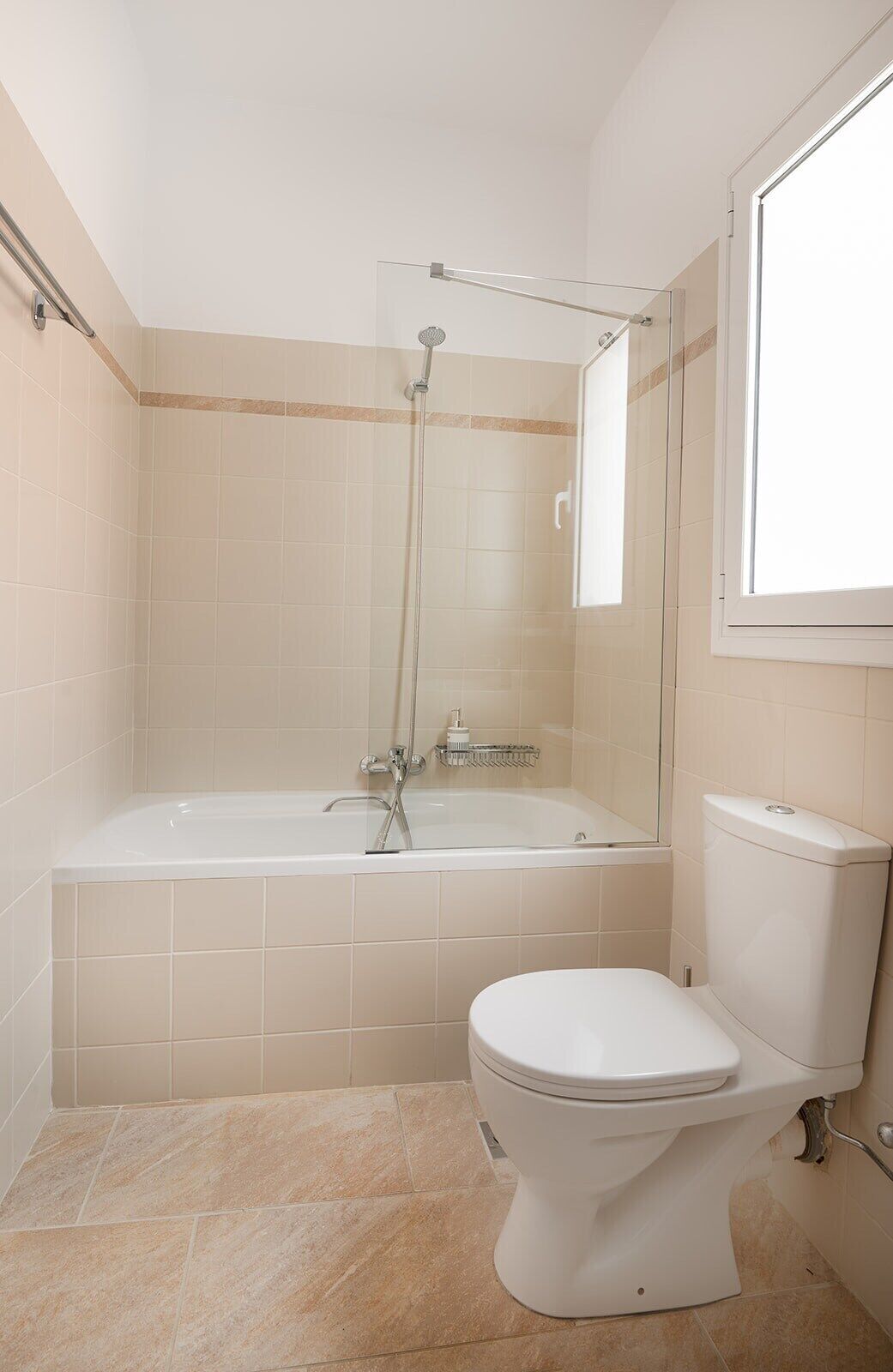 A bathroom with a bathtub, toilet, and a shower enclosure.