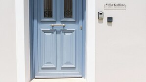 A blue door with a small window, a mailbox, and a stone-tiled base. - Vasilopoulos Residences - Villa Kalliste (Kefalonia)
