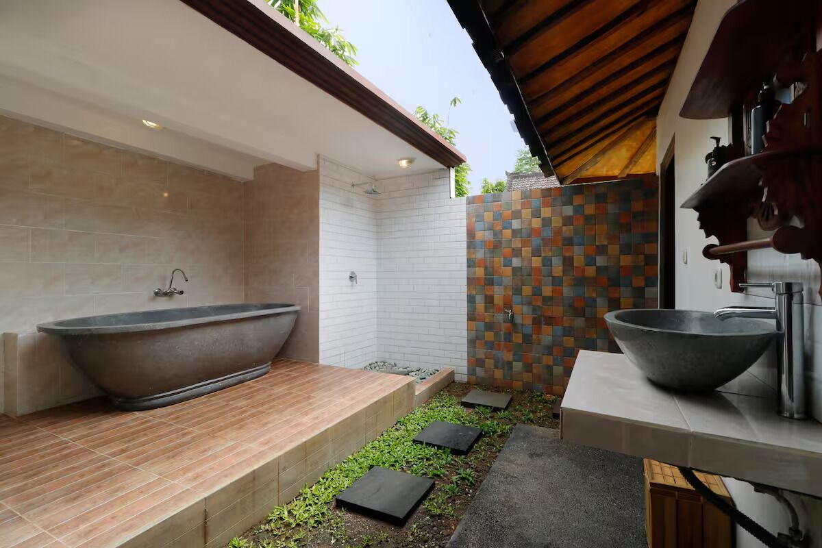 A modern bathroom with a freestanding bathtub, a large basin sink, and a tiled shower area.