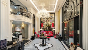 A grand lobby with a chandelier, a red sofa, and a reception desk. - Ella Riverside Lao Cai Hotel (Lao Cai)