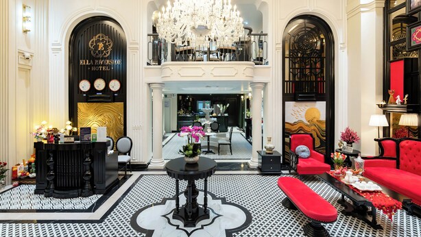 A grand lobby with a chandelier, a reception desk, and a red sofa. - Ella Riverside Lao Cai Hotel (Lao Cai)