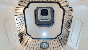 A spiral staircase with a central column and railings on both sides. - Ella Riverside Lao Cai Hotel (Lao Cai)