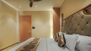 A hotel room with a large bed, a headboard, and a carpeted floor. - Hotel Sign Inn  (Amritsar)
