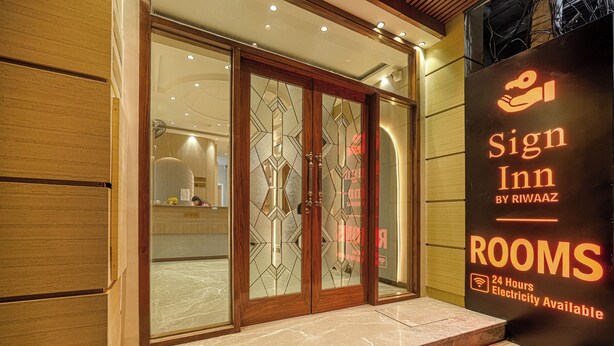 A hotel entrance with a sign indicating 'Sign Inn by RIWAAZ' and '24 Hours Electricity Available'. - Hotel Sign Inn  (Amritsar)