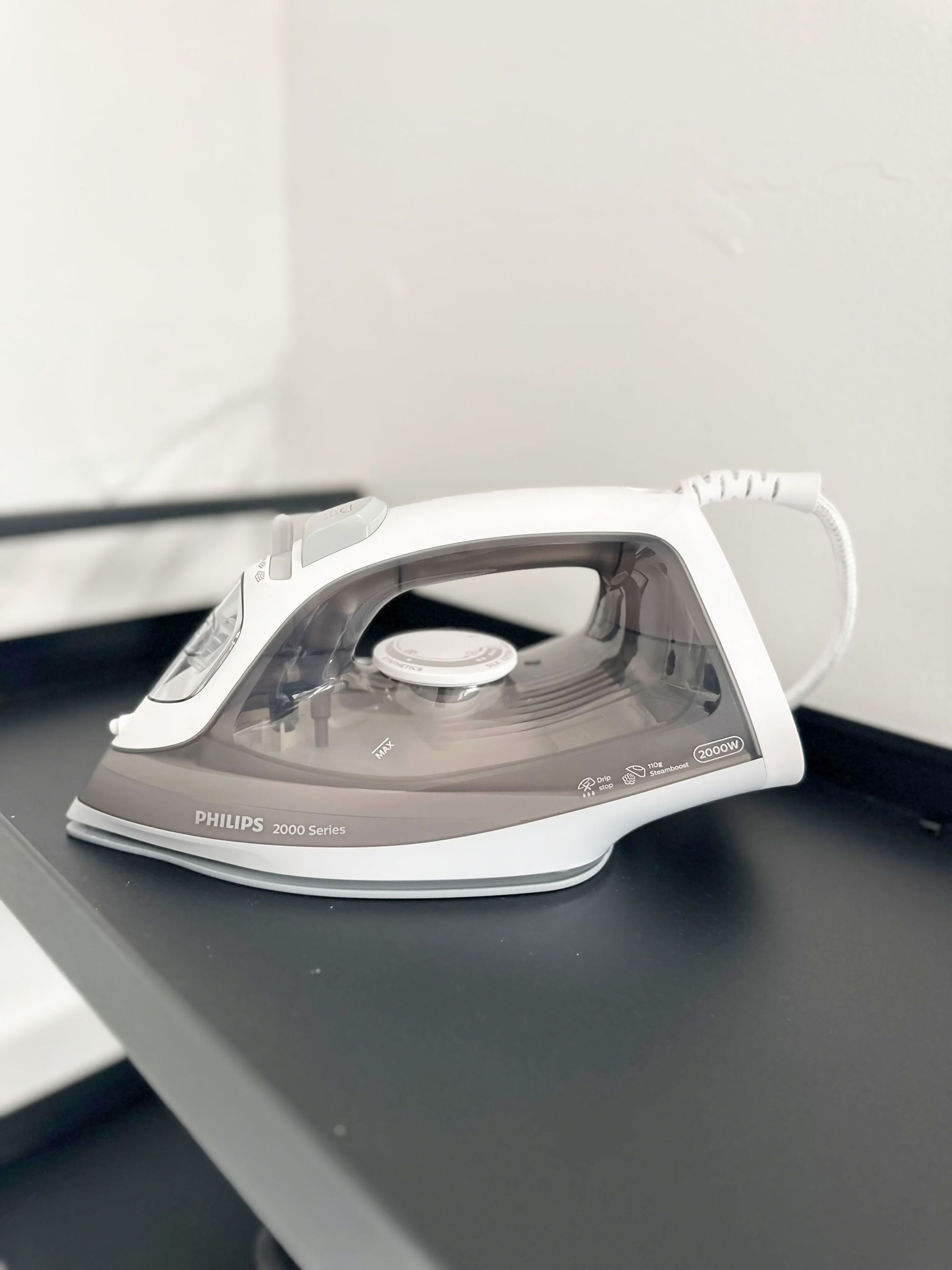 Un fer à repasser Philips de la série 2000, doté d’un réservoir d’eau transparent, d’un système anti-goutte et d’un indicateur de puissance de 2000 W.