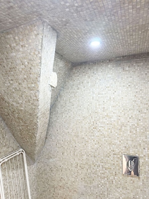 A tiled bathroom with a shower area, a visible drain, and a light fixture on the ceiling. - 2BR Apartment with Canal View in Ghent (Ghent)