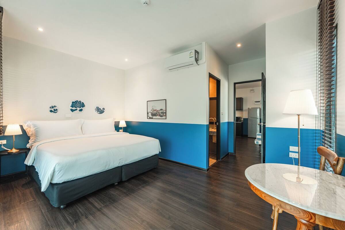 Ein Hotelzimmer mit Bett, Nachttischen, einem runden Tisch und einem durchgegangenen Tür sichtbaren Badezimmer.