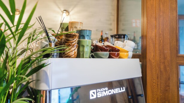 A kitchen counter with various dishes and a Nuova Simonelli appliance. - Modern 3BR Apt for 6 with Patio Ghent (Ghent)