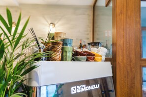 Un plan de travail de cuisine avec différents plats et un appareil de la marque Nuova Simonelli.