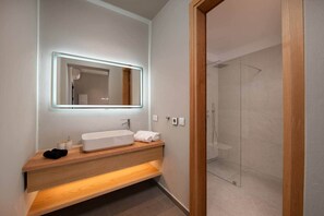 A modern bathroom with a large mirror, a wooden vanity, a white sink, and a glass shower enclosure. - Vista Blue Villas Naxos | 16 Guests (Τοπική Κοινότητα Βίβλου)