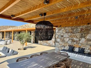 Un espacio al aire libre con paredes de piedra, una lámpara colgante y vistas del paisaje circundante.