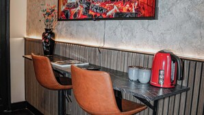 A dining area with a table, two chairs, a red kettle, and a vase with flowers. - Cozy 5BR Apt in the Heart of Ghent (Ghent)