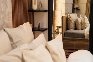 A modern bedroom with a bed, pillows, a nightstand, and a vase. - Cozy 5BR Apt in the Heart of Ghent (Ghent)