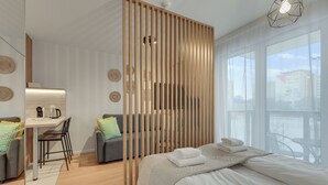 Una habitación de hotel moderna con cama, escritorio y vista a la ciudad.