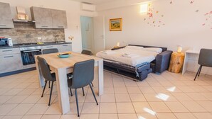 A compact studio apartment with a kitchenette, a dining area, and a bed. - Lake Harmony Suite - One Bedroom Apartment, Sleeps 4 (Manerba del Garda)