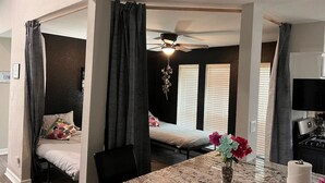 Ein gemütliches Schlafzimmer mit Bett, Deckenventilator und Fenster mit Jalousien.