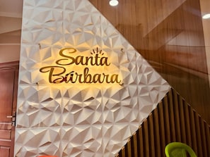 A geometric wall design with the text 'Santa Bárbara' illuminated in gold.