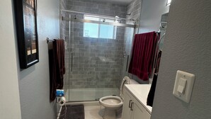Ein Badezimmer mit Dusche, Toilette und Waschbecken.