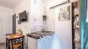 Une petite cuisine équipée d’une cuisinière, d’un évier et d’un petit réfrigérateur.
