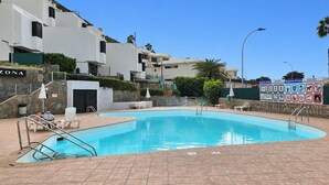 Une piscine dotée de chaises longues et d’un panneau affichant divers symboles.
