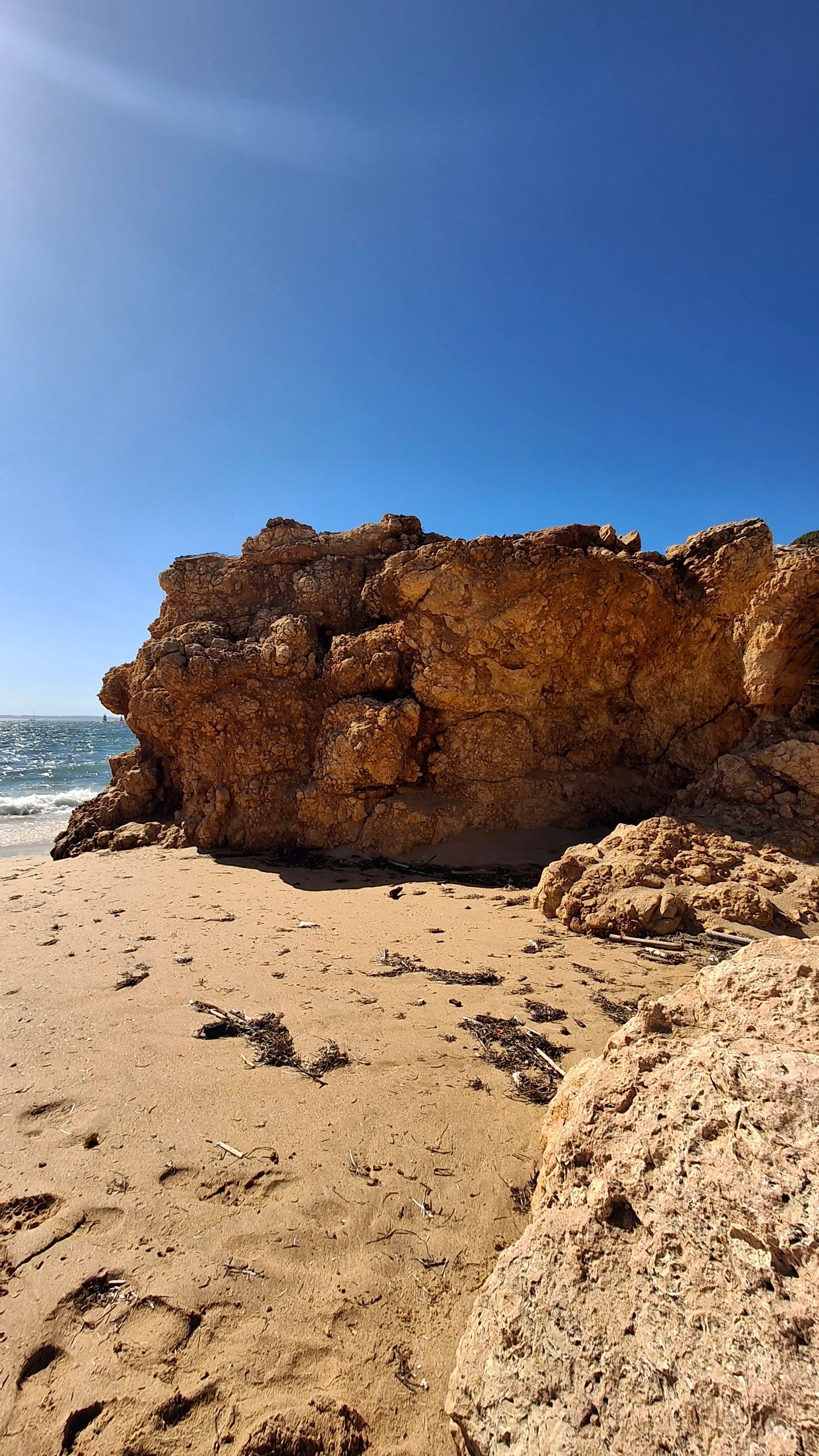 A rocky beach with clear blue sky.