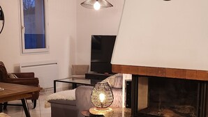 Un salón con chimenea, un reloj y un felpudo con estampado de cebra.