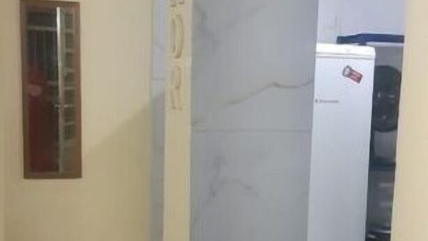 Cozinha com backsplash de mármore, bancada e geladeira.