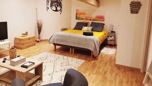 A bedroom with a bed, bedside table, lamp, and a painting on the wall. - La Grange de Cablanc (Monestier)