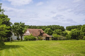 A house with a red roof, surrounded by a grassy field and trees. - La Grange de Cablanc (Monestier)