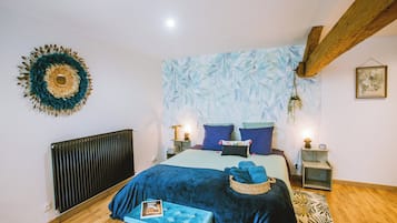 Un dormitorio con una cama, un radiador, un tapiz en la pared y una viga de techo de madera.