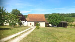 A rural property with a single-story building, a dirt path leading to the entrance, and a small shed in the background. - La Grange de Cablanc (Monestier)