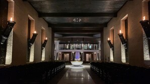 Eine Hotelhalle mit einer zentralen Fontäne, Sitzreihen und modernem architektonischen Design.