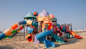 A colorful playground with slides and climbing structures on a sandy beach. - Residence Sandra three-room apartment Trilo for 6 persons (Rosolina Mare)