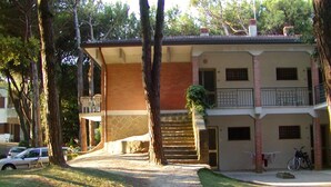 A two-story building with a central staircase, a balcony on the upper floor, and a small garden area. - Residence Sandra three-room apartment Trilo for 6 persons (Rosolina Mare)