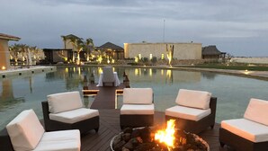 Un espace aménagé au bord de la piscine, avec des chaises longues et un foyer.