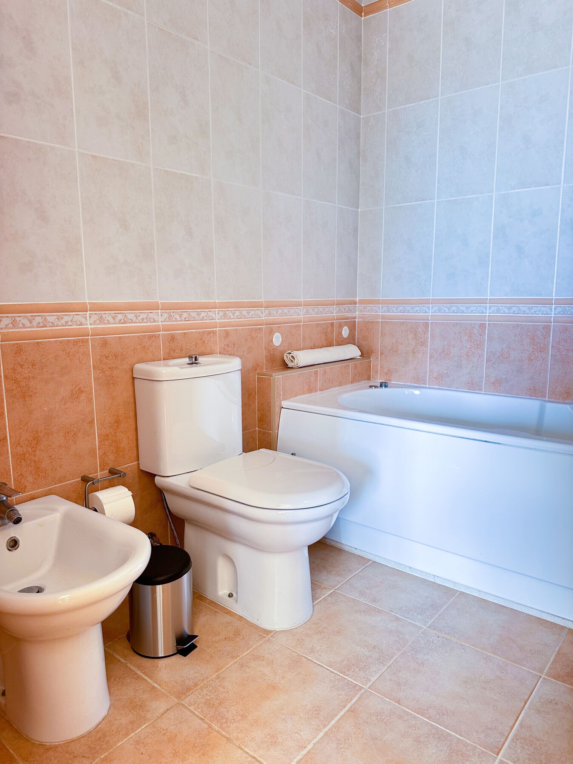 Une salle de bain équipée de toilettes, d’un bidet, d’un lavabo et d’une baignoire.