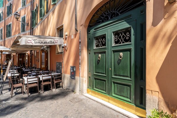 A restaurant with outdoor seating, a green door, and a sign reading 'Tonnarello.' - Zenaria Trastevere, Zen Design in Heart of Rome (Rome)