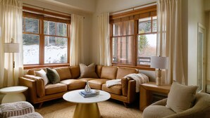 A cozy living room with a brown leather sofa, a round coffee table, and a small side table.