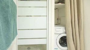 Een wasserette met een wasmachine en een droogrek.
