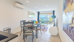 Un salon moderne comprenant un coin repas, une grande fenêtre et une vue sur l’extérieur.