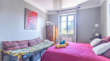 Un dormitorio con cama, sofá, cómoda y ventana.