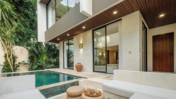 A modern outdoor pool area with white furniture, a wooden bench, and a glass table with drinks. - Quiet Luxury Villa Uluwatu. Private Pool, Workspace, Airport Pick Up & Butler (Bali)