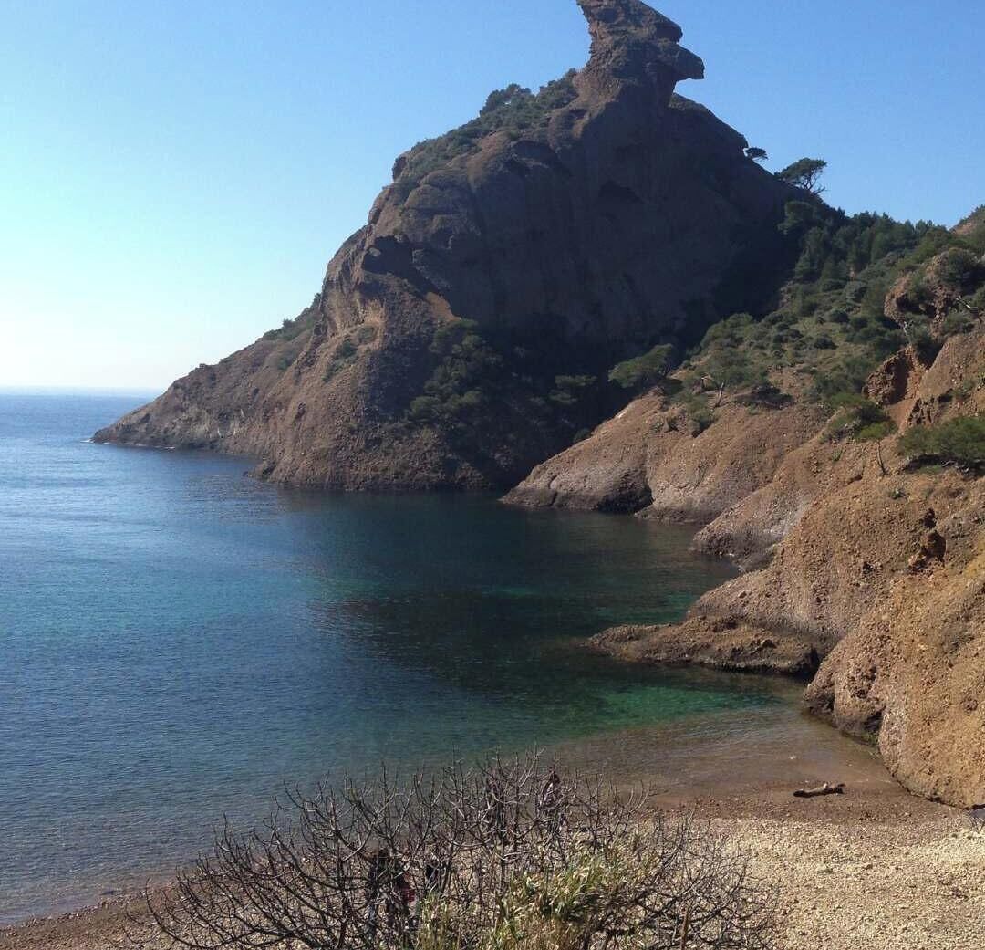 Un paisaje costero con un imponente risco y aguas azul cristalino.