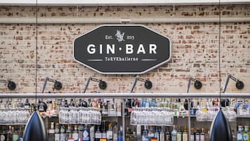 A bar with a sign reading 'GIN BAR' and a brick wall background.