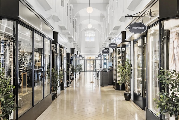 A corridor with glass-fronted shops, including a jewelry store and a hotel. - Villavejle Hotel, BW Signature Collection (Vejle)