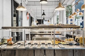 A buffet counter with labeled food sections including brie, salami, ham, cheese, fruit, butter, and yogurt. - Villavejle Hotel, BW Signature Collection (Vejle)