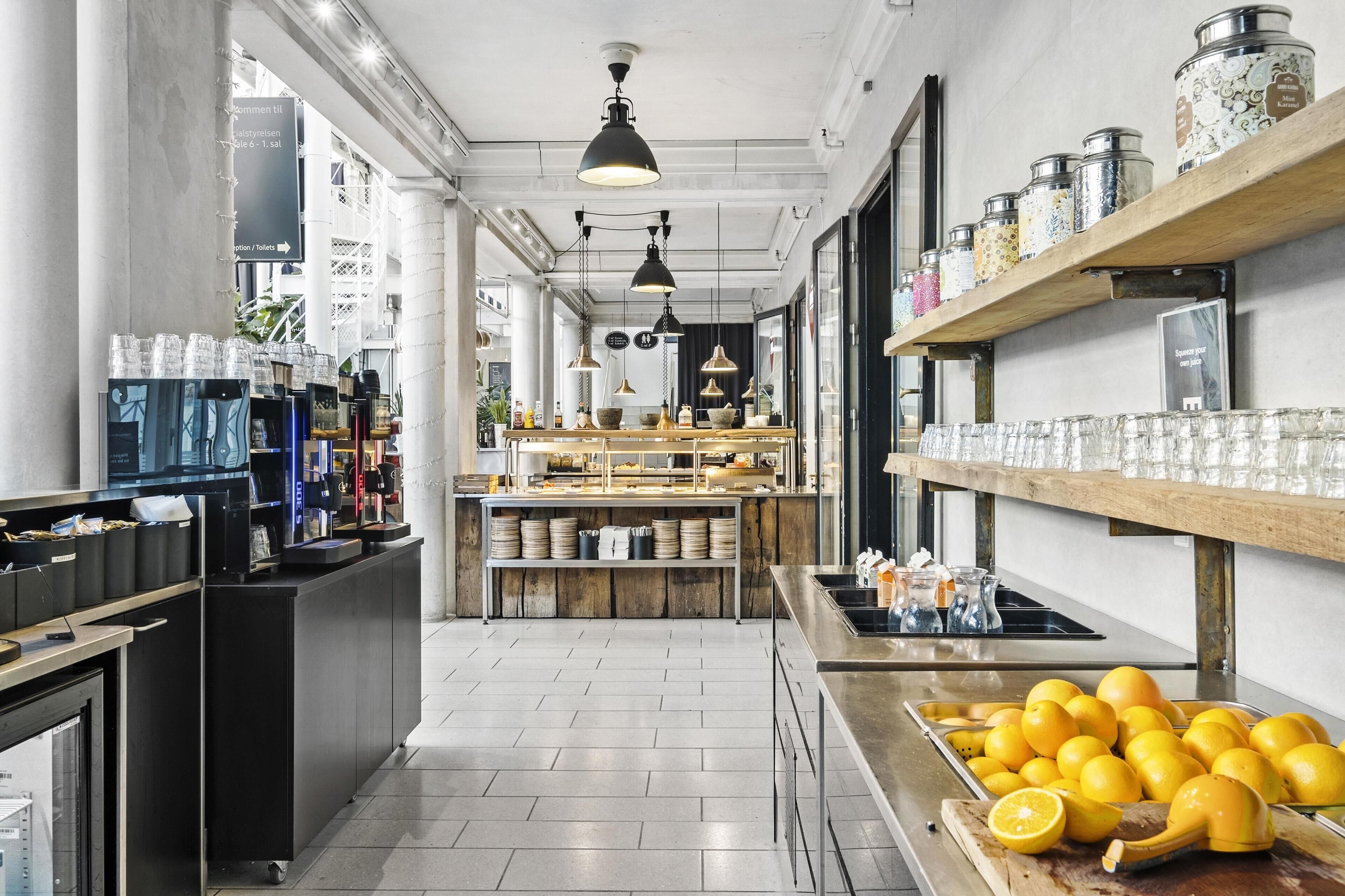 A modern kitchen with a central island, a coffee machine, and a variety of kitchenware on shelves.